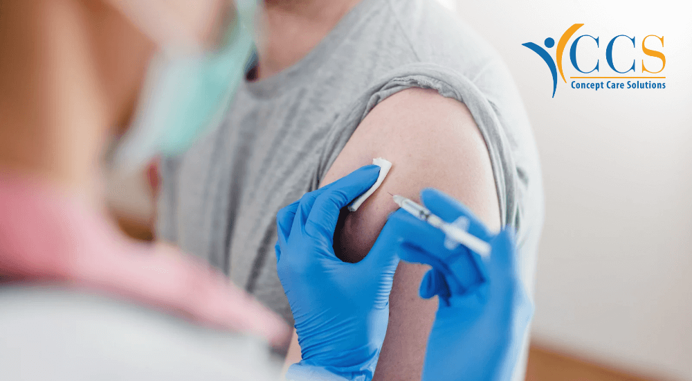 A healthcare professional wearing blue gloves administering a vaccine to a patient's upper arm.