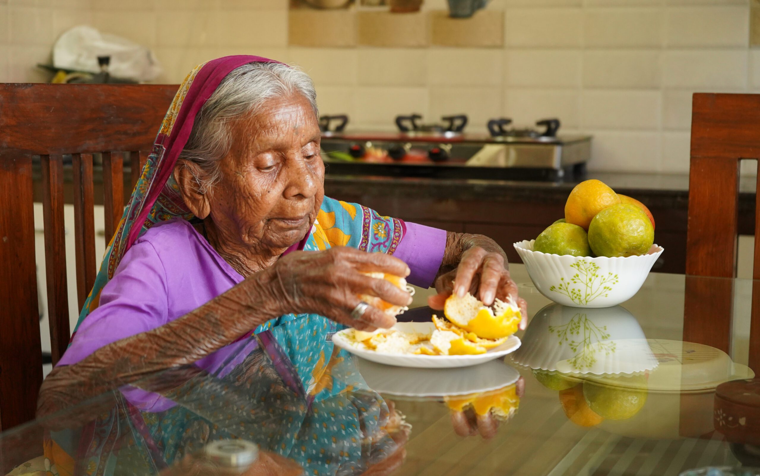 Elderly Indian woman enjoying a healthy meal of fruit at home
