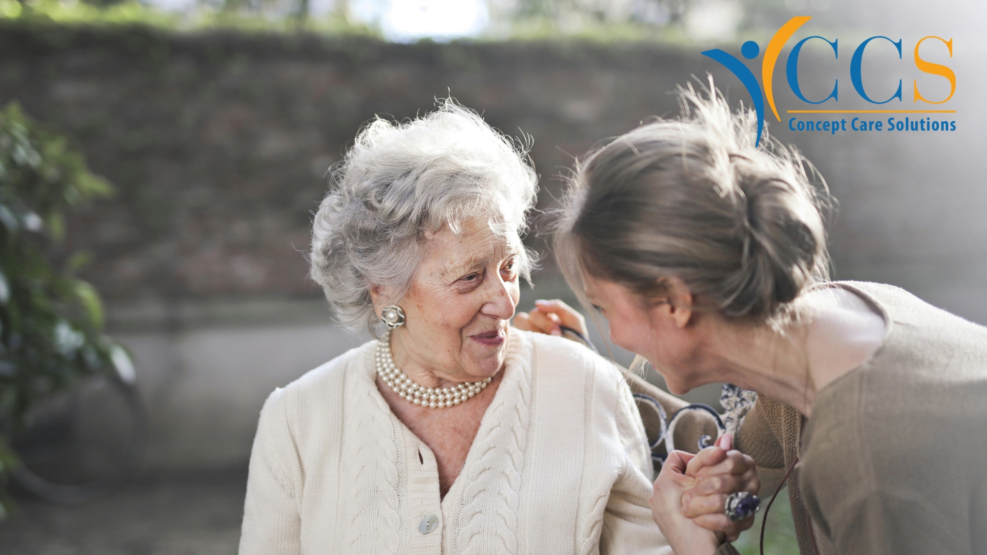 Older woman smiling with her carer at home, highlighting wellbeing and support for women experiencing menopause over 70.